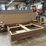 Individueller Bett-Prototyp mit Holzwand und schwebenden Nachttischen