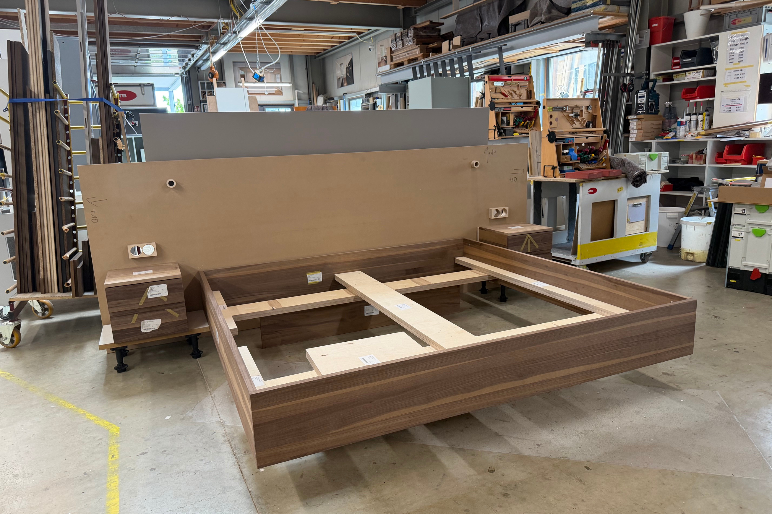 Individueller Bett-Prototyp mit Holzwand und schwebenden Nachttischen Individueller Bett-Prototyp mit Holzwand und schwebenden Nachttischen